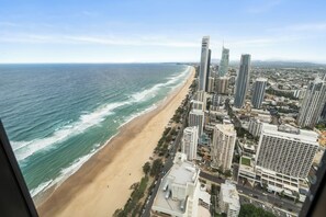 Eine Küstenstadt mit Hochhäusern, einem Strand und klarem Himmel.