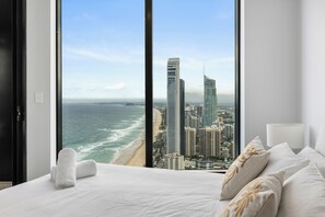 A hotel room with a large window offering a view of the ocean and city skyline. - Ocean Luxe Retreat 2  Kingbeds Free Parking (Surfers Paradise)