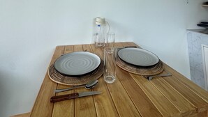 A dining table with plates, cutlery, and a glass pitcher set for two. - Boho House • 2 mn DeviDeli • Hin Kong • 4K Tv • AC (Koh Phangan)