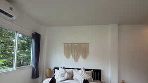 A neatly made bed with a striped blanket and two brown slippers placed on it. - Boho House • 2 mn DeviDeli • Hin Kong • 4K Tv • AC (Koh Phangan)