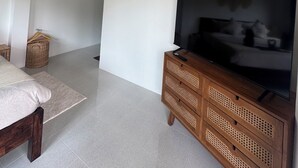 A modern bedroom with a bed, a wooden TV stand, and decorative wall art. - Boho House • 2 mn DeviDeli • Hin Kong • 4K Tv • AC (Koh Phangan)