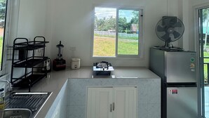 A modern kitchen with a gas stove, a sink, a refrigerator, and a window with a view of greenery outside. - Boho House • 2 mn DeviDeli • Hin Kong • 4K Tv • AC (Koh Phangan)