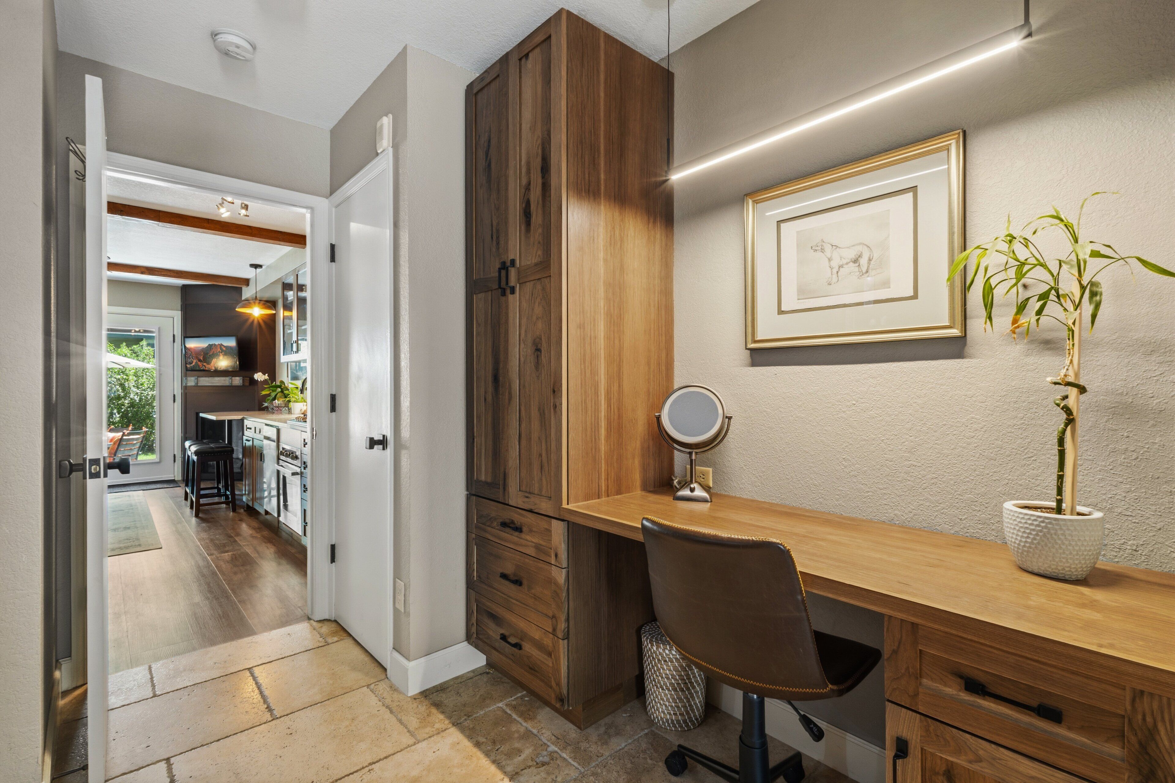 Una cocina moderna con alacenas de madera, un comedor y vista al salón.