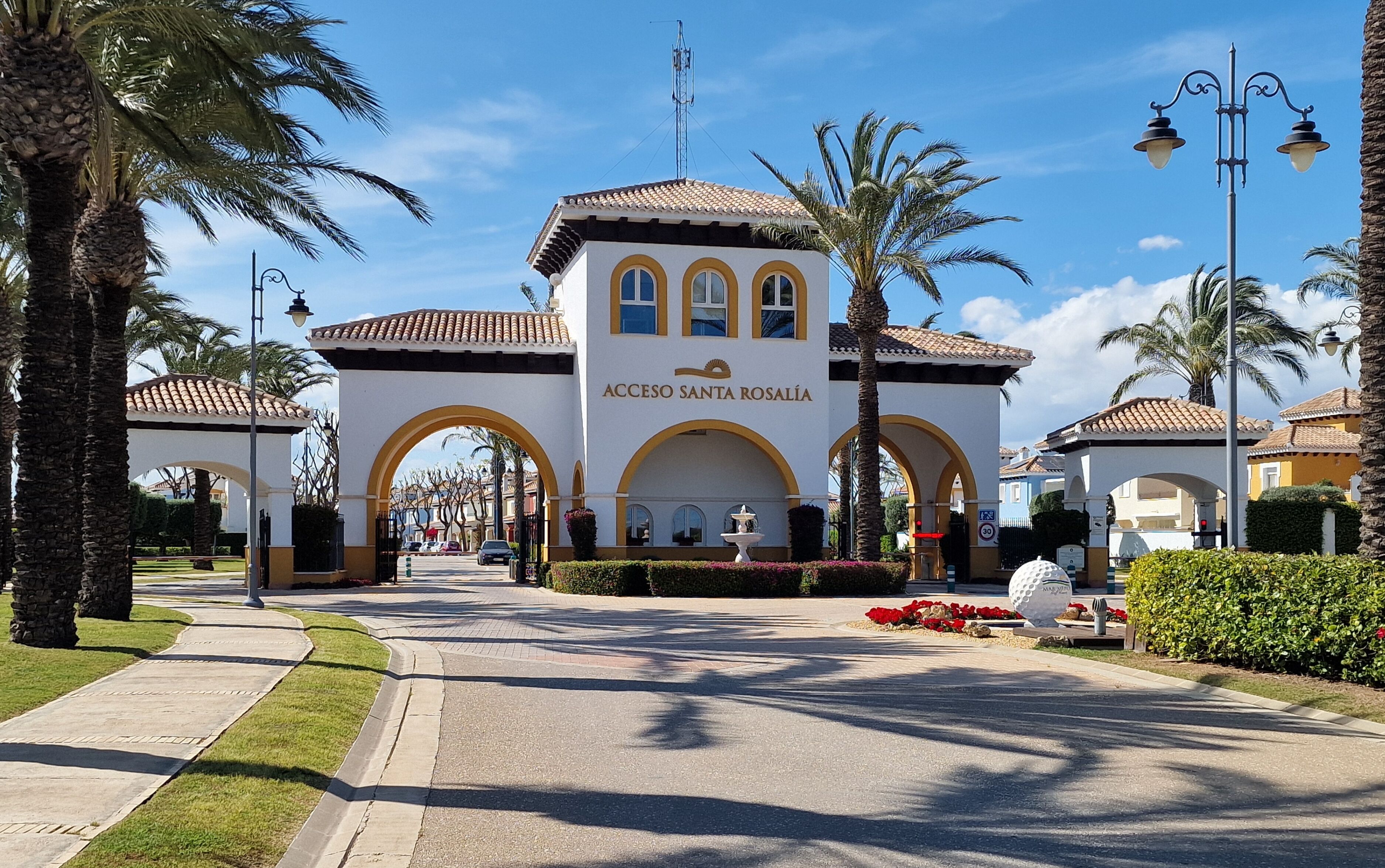 A building with a white facade, arched entrance, and a sign reading "Acceso Santa Rosalía".