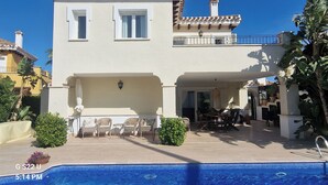 A two-story building with a swimming pool in the foreground.