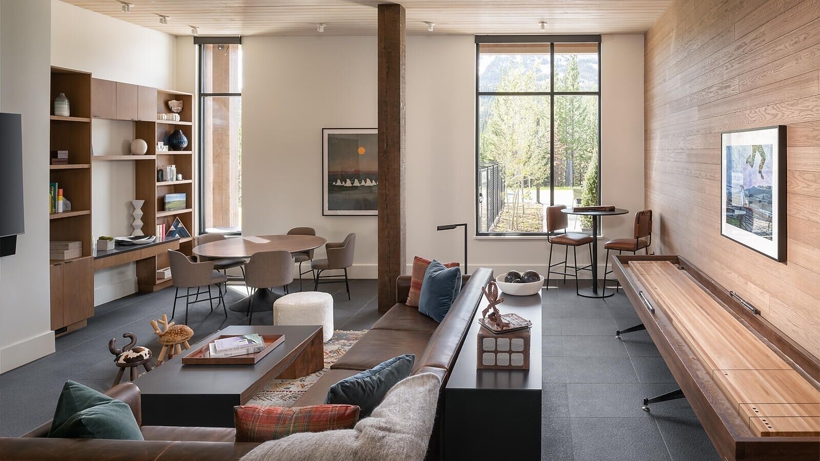 A modern living room with a sofa, coffee table, and a dining area with chairs and a table.