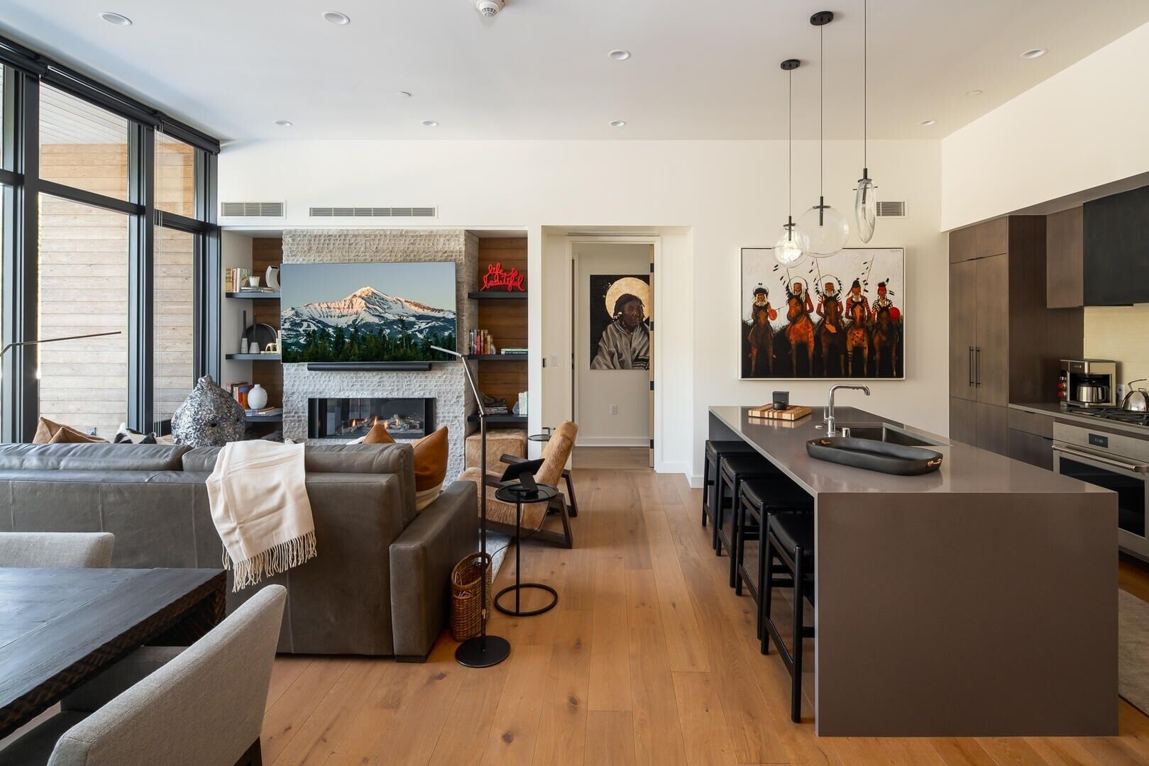 A modern open-plan living space with a fireplace, a dining area, and a kitchen.