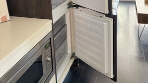 A modern kitchen with a built-in refrigerator, a microwave, and a wooden cabinet. - Burnaby Metropolis Metrotown/1bedroom Condo/AC/Skytrain/Pool/Gym (Burnaby)