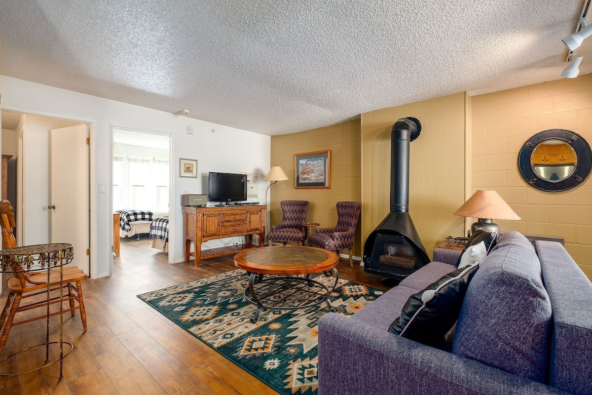 A living room with a fireplace, a sofa, a coffee table, and a TV.