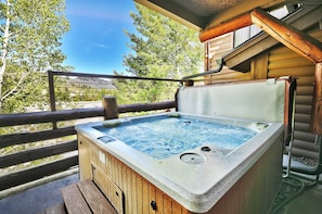 A hot tub on a wooden deck with a view of trees and mountains. - Park City Ski Resort Resort Vacation Homes (Park City)
