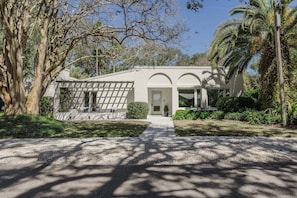 Una casa moderna con fachada simétrica, ventanas amplias y una entrada central.