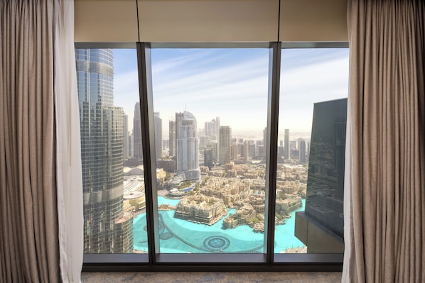 A high-rise hotel room with a panoramic view of a cityscape and a marina.
