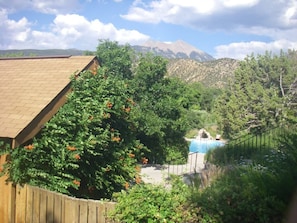 Ein Wohngebiet mit Swimmingpool, umgeben von Bäumen und Bergen im Hintergrund.