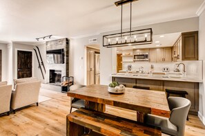 A modern kitchen with a wooden dining table, built-in appliances, and a large window. - Park City Ski Resort - Park Station Condos (Park City)