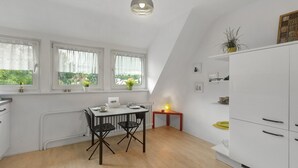 A kitchen with a dining table, chairs, a radiator, and a cabinet. - Apartment 'Ruhepol, 75qm' with Shared Pool, Shared Garden and Wi-Fi (Vellmar)