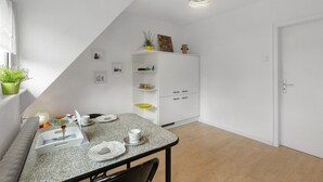 A small, modern kitchen with a dining table, white cabinets, and a ceiling light fixture. - Apartment 'Ruhepol, 75qm' with Shared Pool, Shared Garden and Wi-Fi (Vellmar)