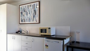 A modern kitchen with a microwave, sink, and dishwasher. - Victory Hotel Motel Gympie  (Gympie)