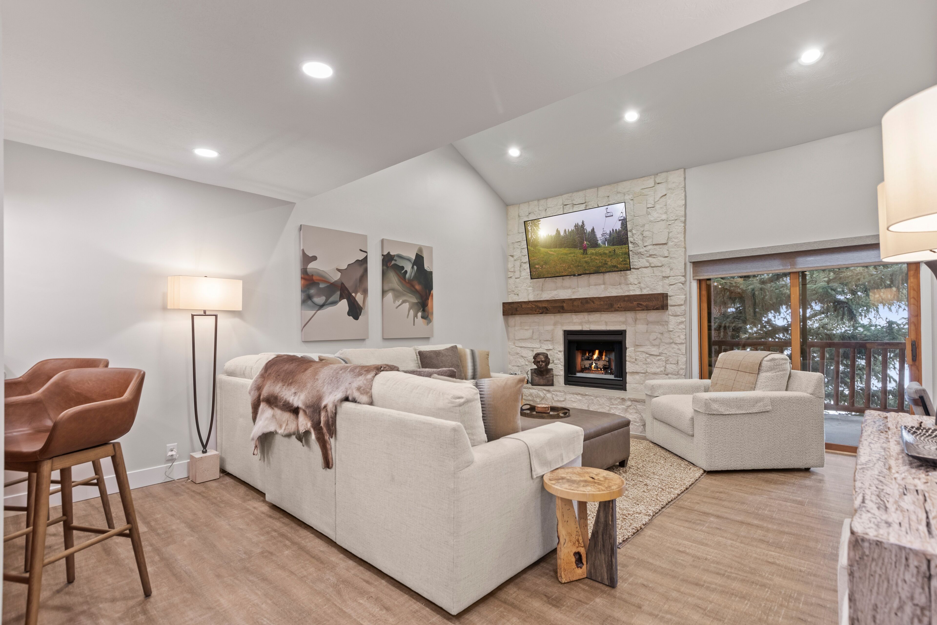 A modern living room with a fireplace, comfortable seating, and artwork on the walls.