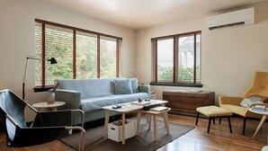 A modern living room with a sofa, a chair, a desk, and a lamp.