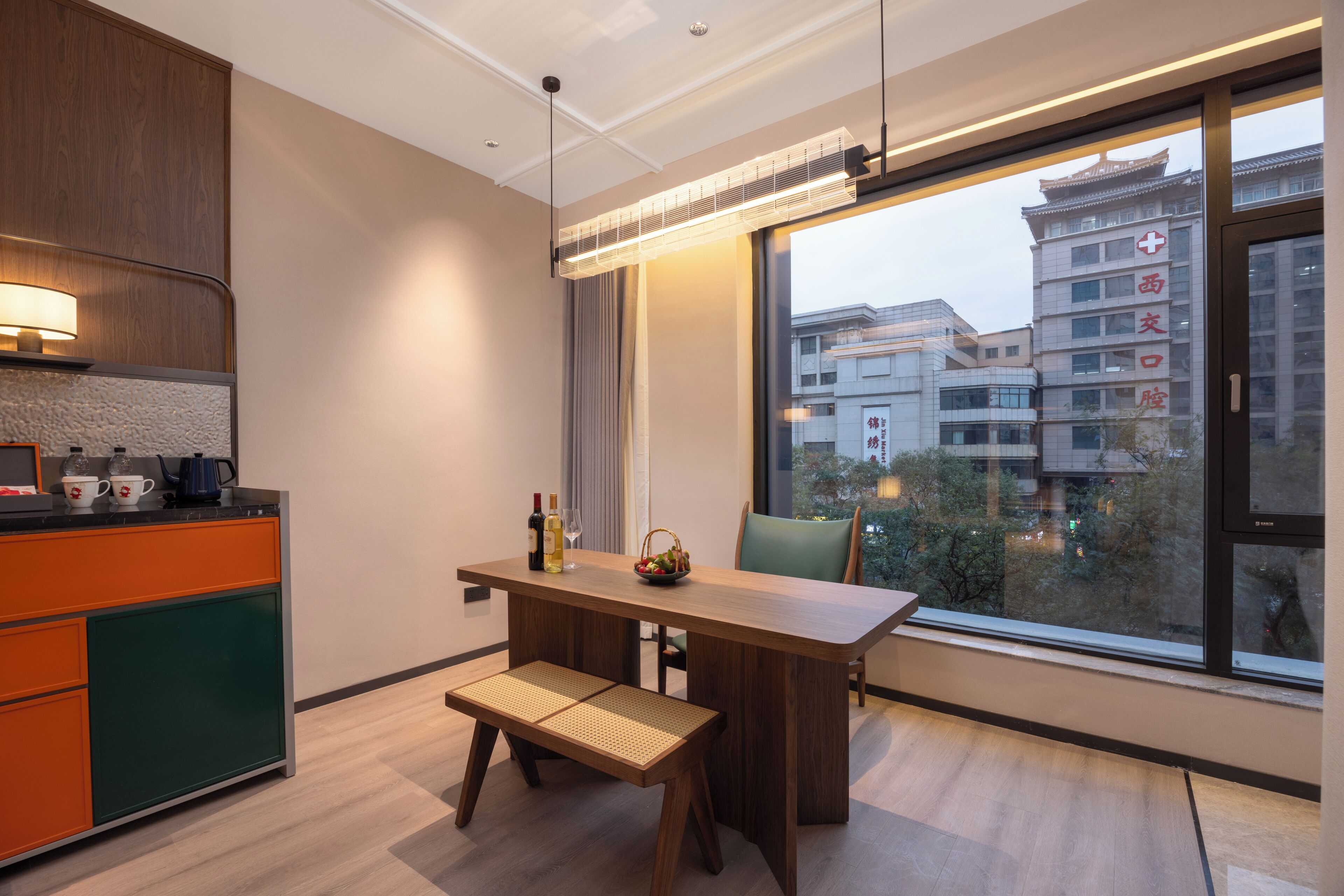 A modern kitchen with a wooden countertop, a built-in oven, and a window overlooking a cityscape.