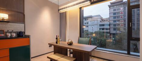 A modern kitchen with a wooden countertop, a built-in oven, and a window overlooking a cityscape.