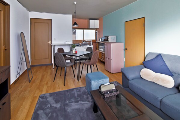 Un espace de vie compact comprenant un coin repas, une kitchenette et un coin salon.
