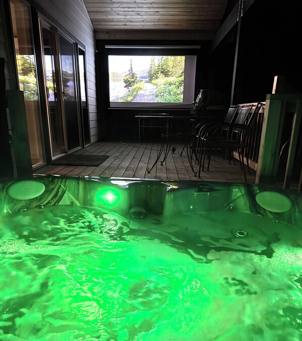 A hot tub area with a view of a garden through a window.