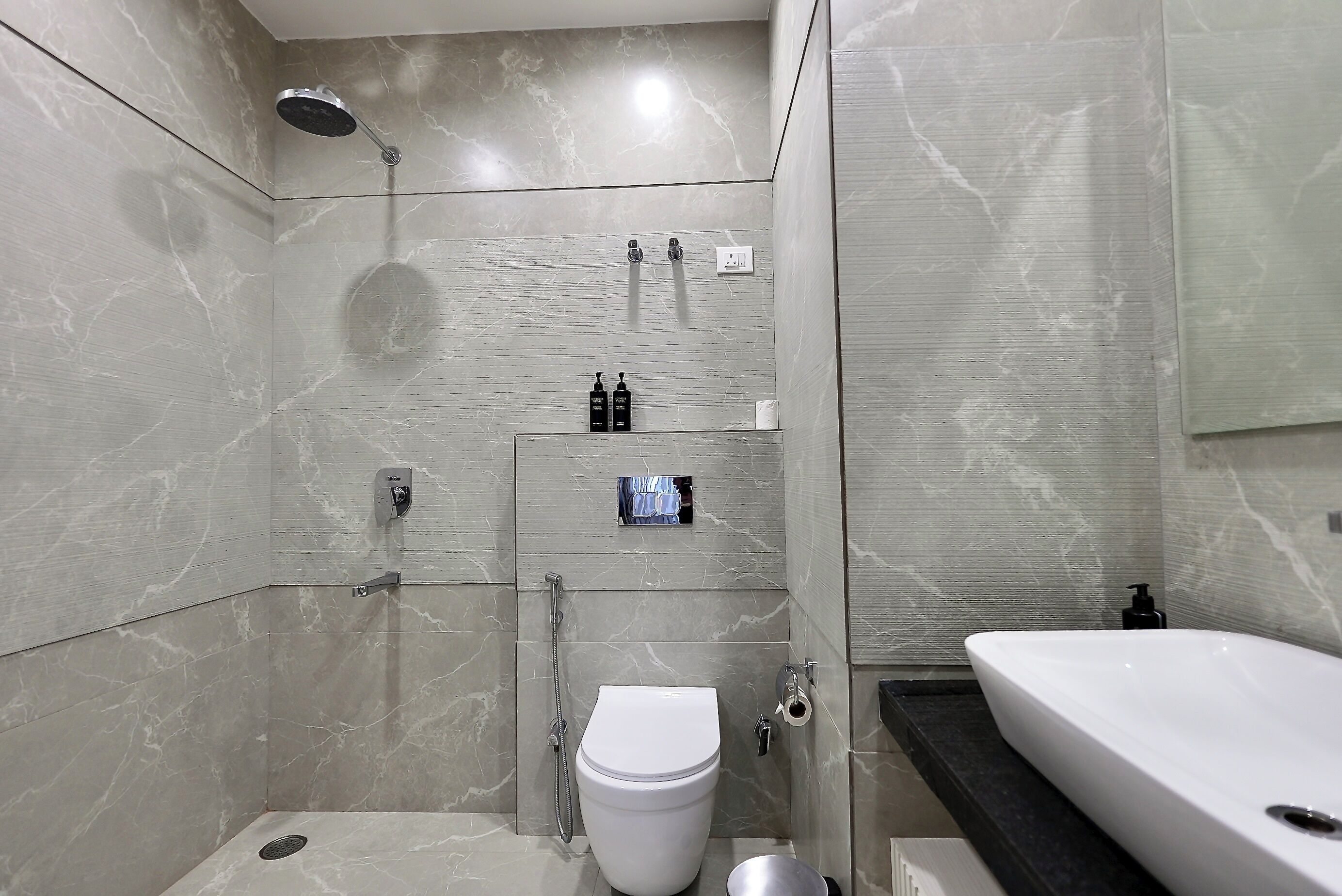 Un baño moderno con ducha, inodoro y lavamanos.