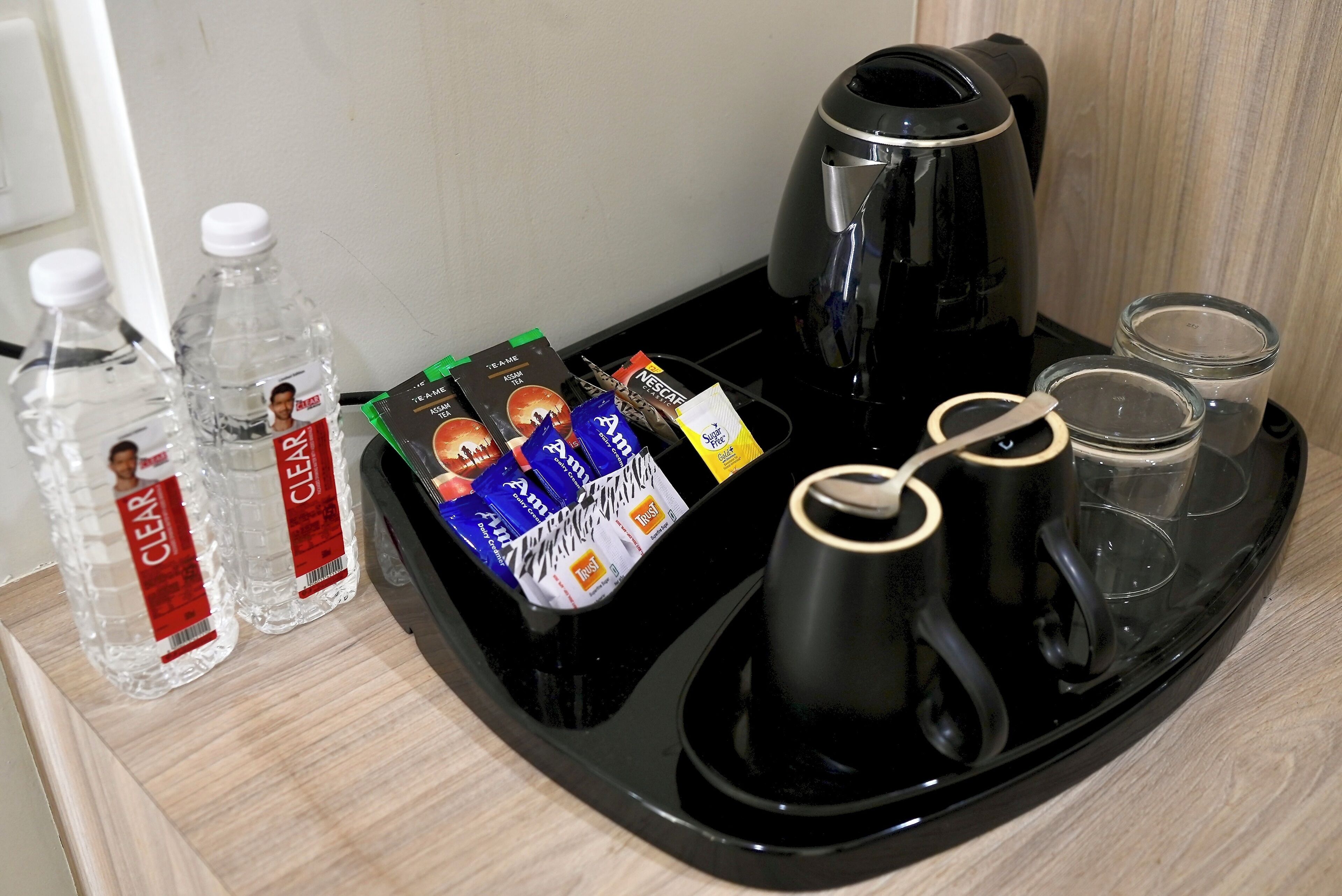 A tray with a coffee maker, two water bottles, and several food packets.