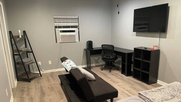 Une pièce comprenant un lit, un bureau, une chaise, une échelle et un téléviseur.