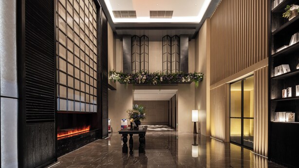 A modern lobby with a fireplace, a reception desk, and a bookshelf. - UrCove by Hyatt Guangzhou Huadu Baiyun International Airport (Guangzhou)