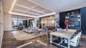 A spacious living area with a large dining table, sofas, and a bookshelf. - UrCove by Hyatt Guangzhou Huadu Baiyun International Airport (Guangzhou)