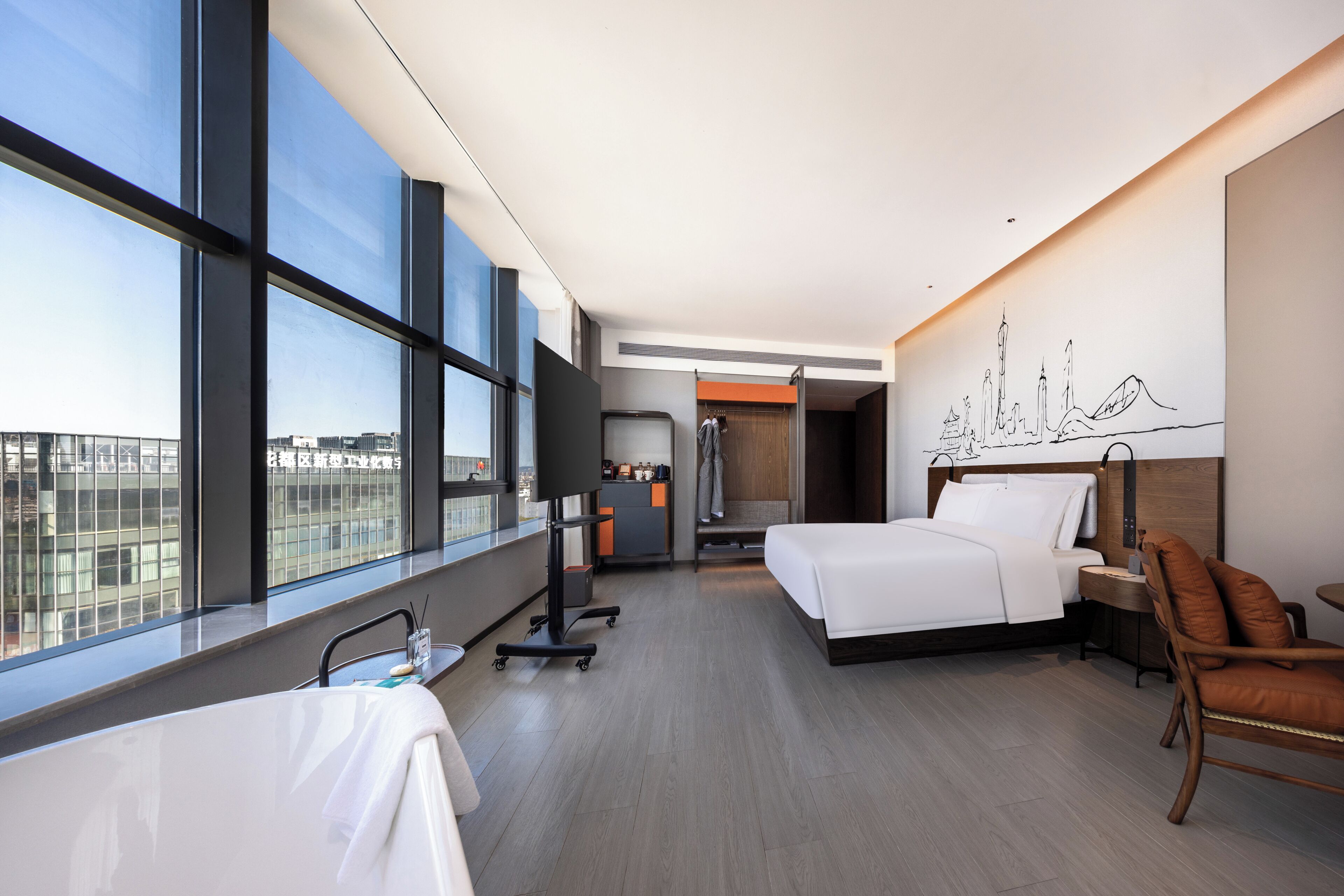 Une chambre d’hôtel moderne avec deux lits, un bureau, une chaise, une télévision et une vue sur la ville.