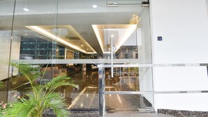 A modern hotel lobby with glass doors, a reception desk, and a staircase leading to upper floors. - Palette KL Sentral near Pudu LRT formerly RPC Blissful Homes (Kuala Lumpur)