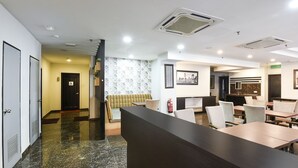 A hotel lobby with a reception desk, seating area, and a staircase leading to another floor. - Palette KL Sentral near Pudu LRT formerly RPC Blissful Homes (Kuala Lumpur)