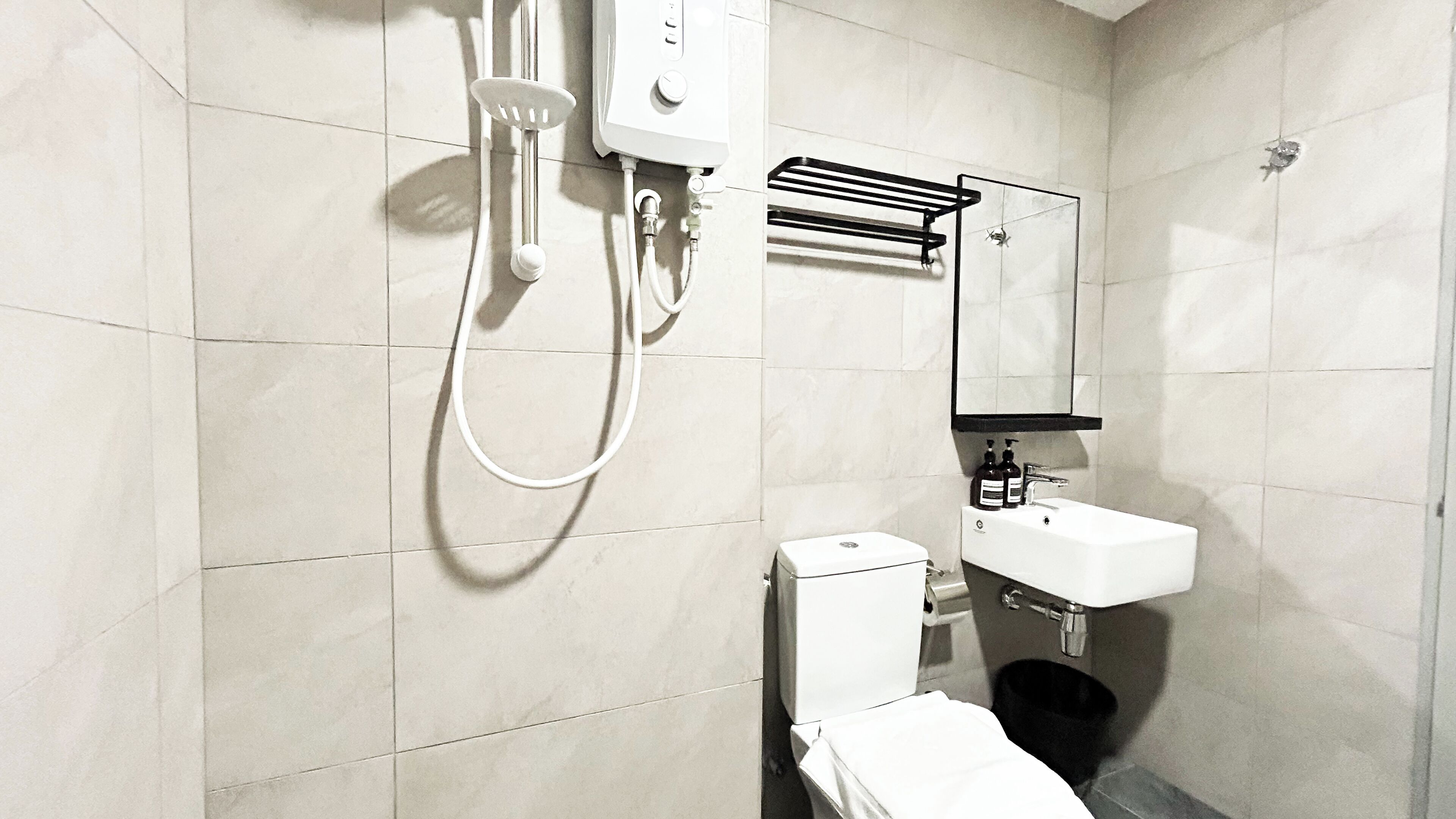 A modern bathroom with a toilet, sink, and shower unit.