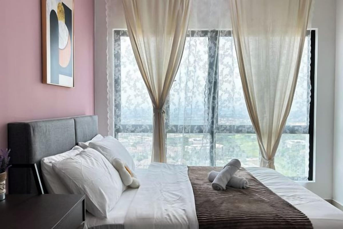 Una camera da letto con un'ampia finestra, un letto con biancheria bianca, una testiera e un comodino con una lampada.