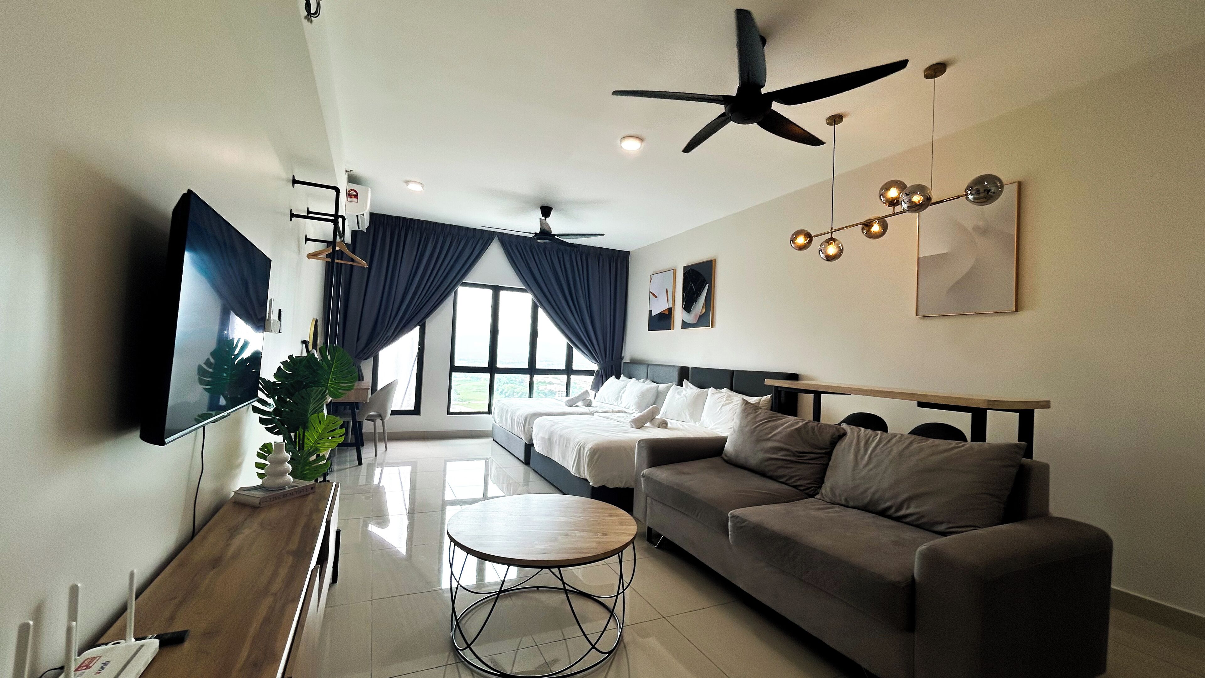 A modern living room with a sofa, a coffee table, a TV, and a ceiling fan.