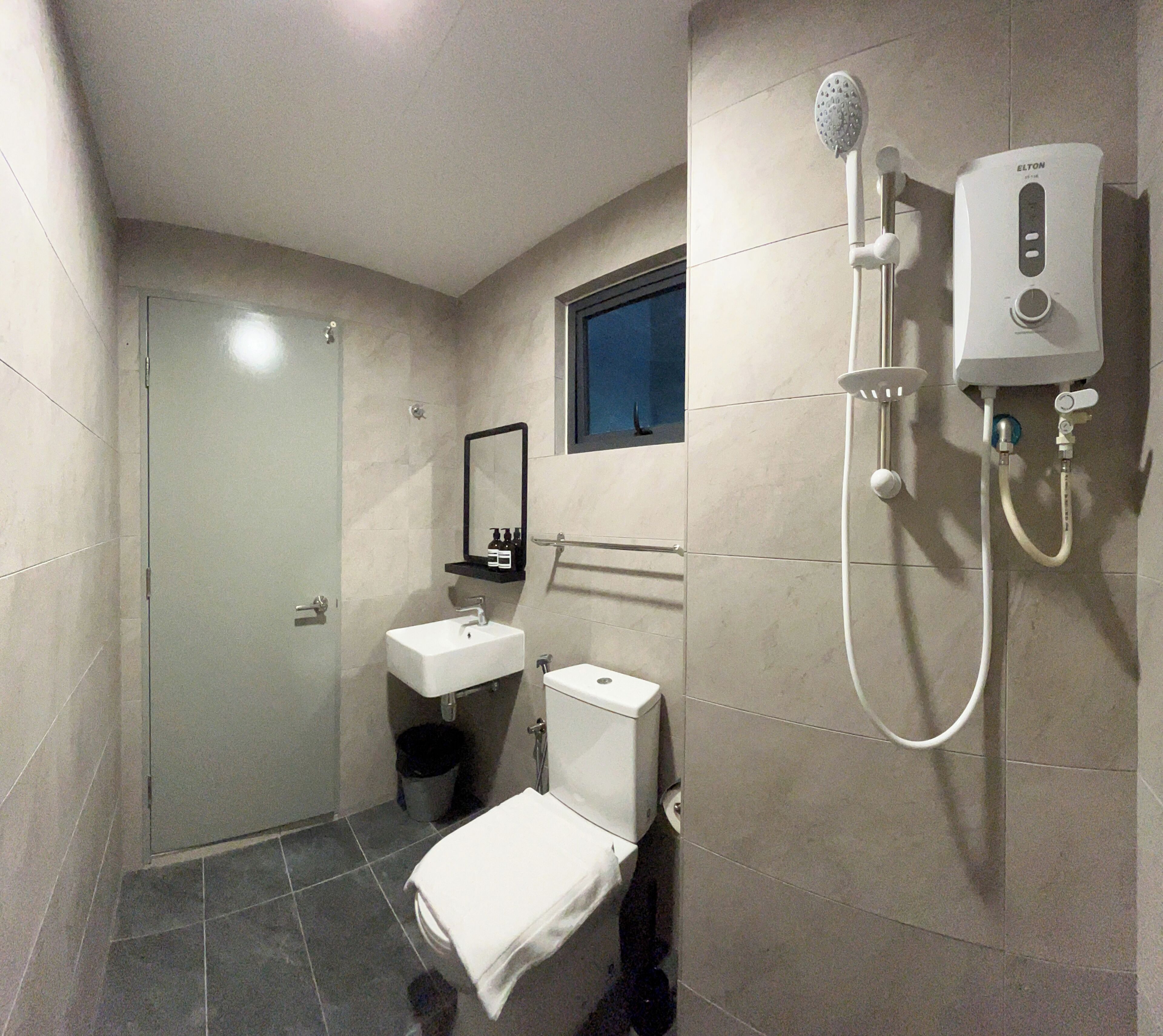 A compact bathroom with a toilet, sink, and shower unit.
