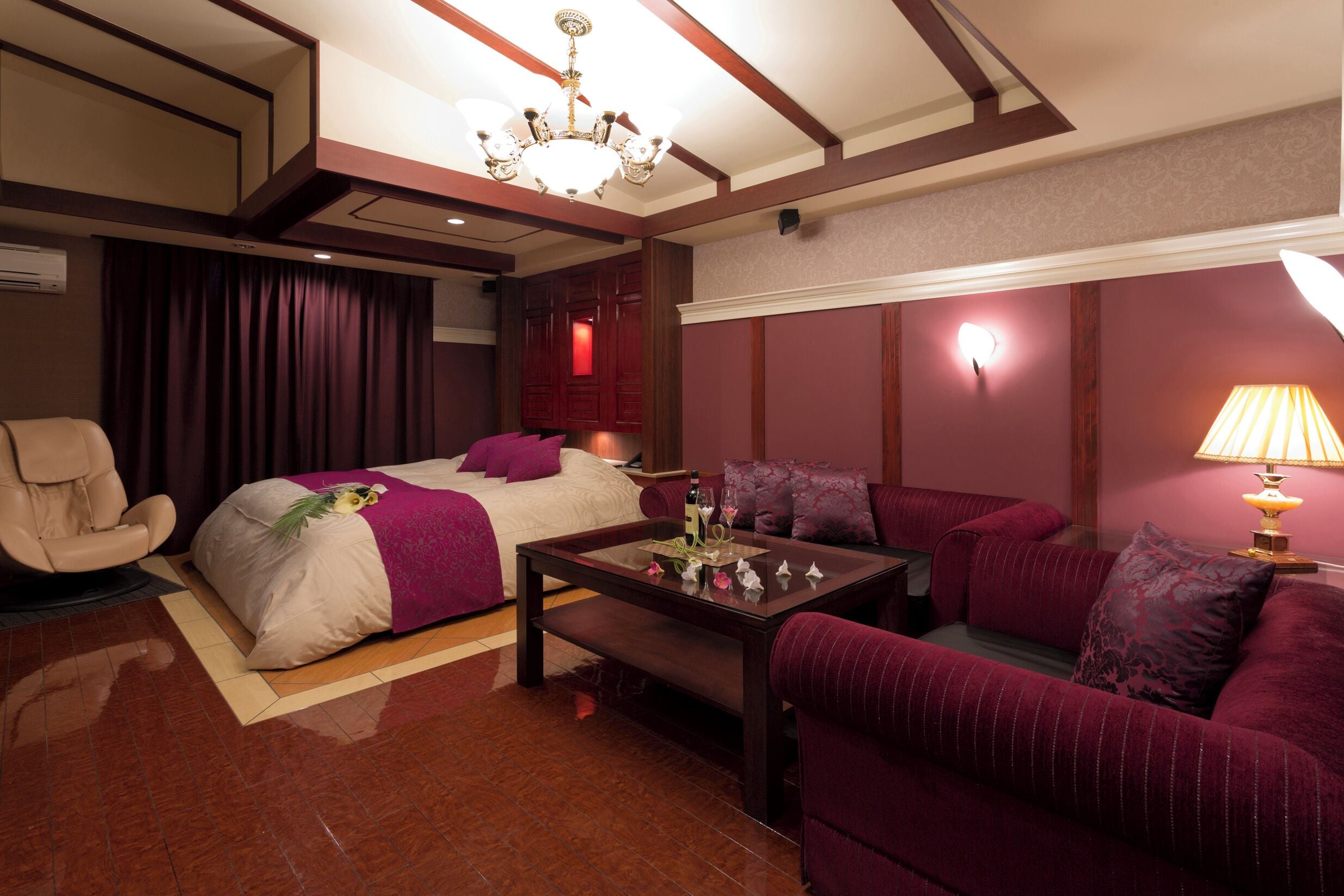 Une chambre d’hôtel comprenant un lit, un canapé, une chaise, une table basse et une lampe.