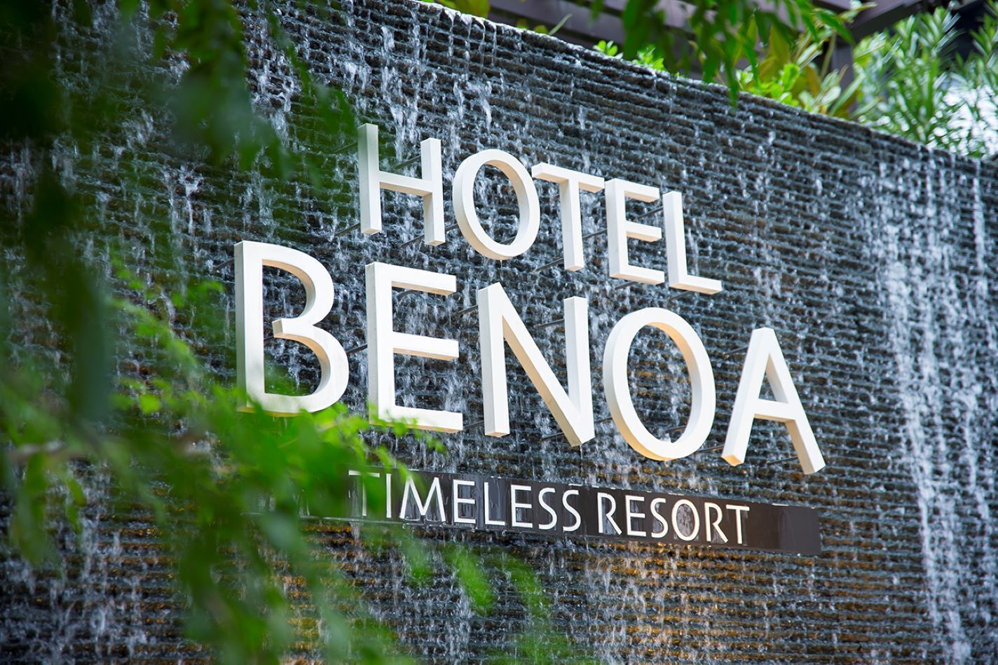 Señal de Hotel Benoa, con un paisaje de cascada de fondo.
