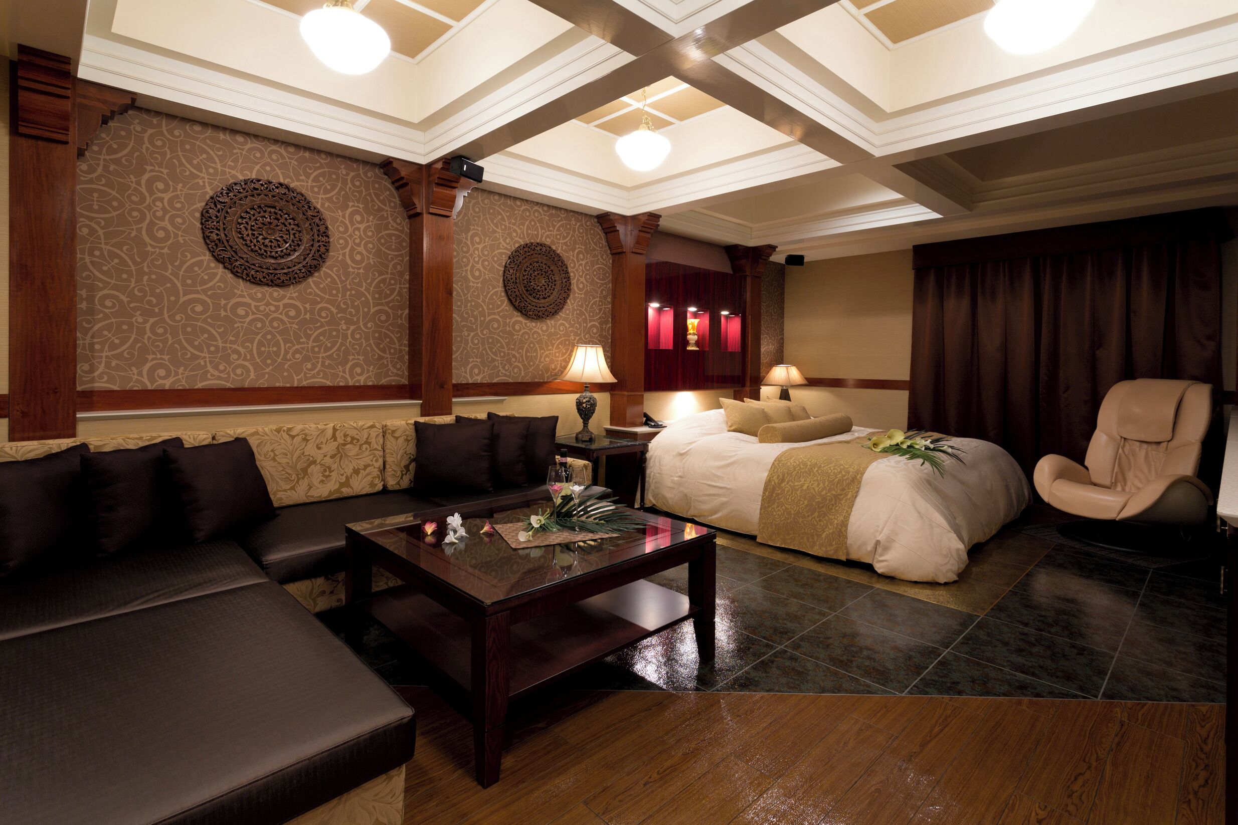 A hotel room with a sofa, a bed, a chair, and a coffee table.