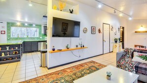 Un salon moderne avec un canapé, une table basse et un téléviseur fixé au mur.