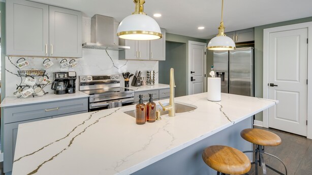 A modern kitchen with marble countertops, stainless steel appliances, and pendant lighting. - Family Friendly: Modern Apt in Fort Washington (Fort Washington)