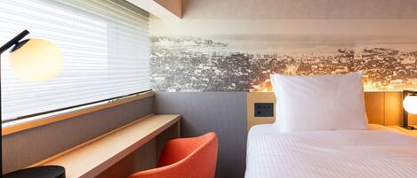 A hotel room with a bed, a desk, a chair, a window with blinds, and a wall with a cityscape mural.