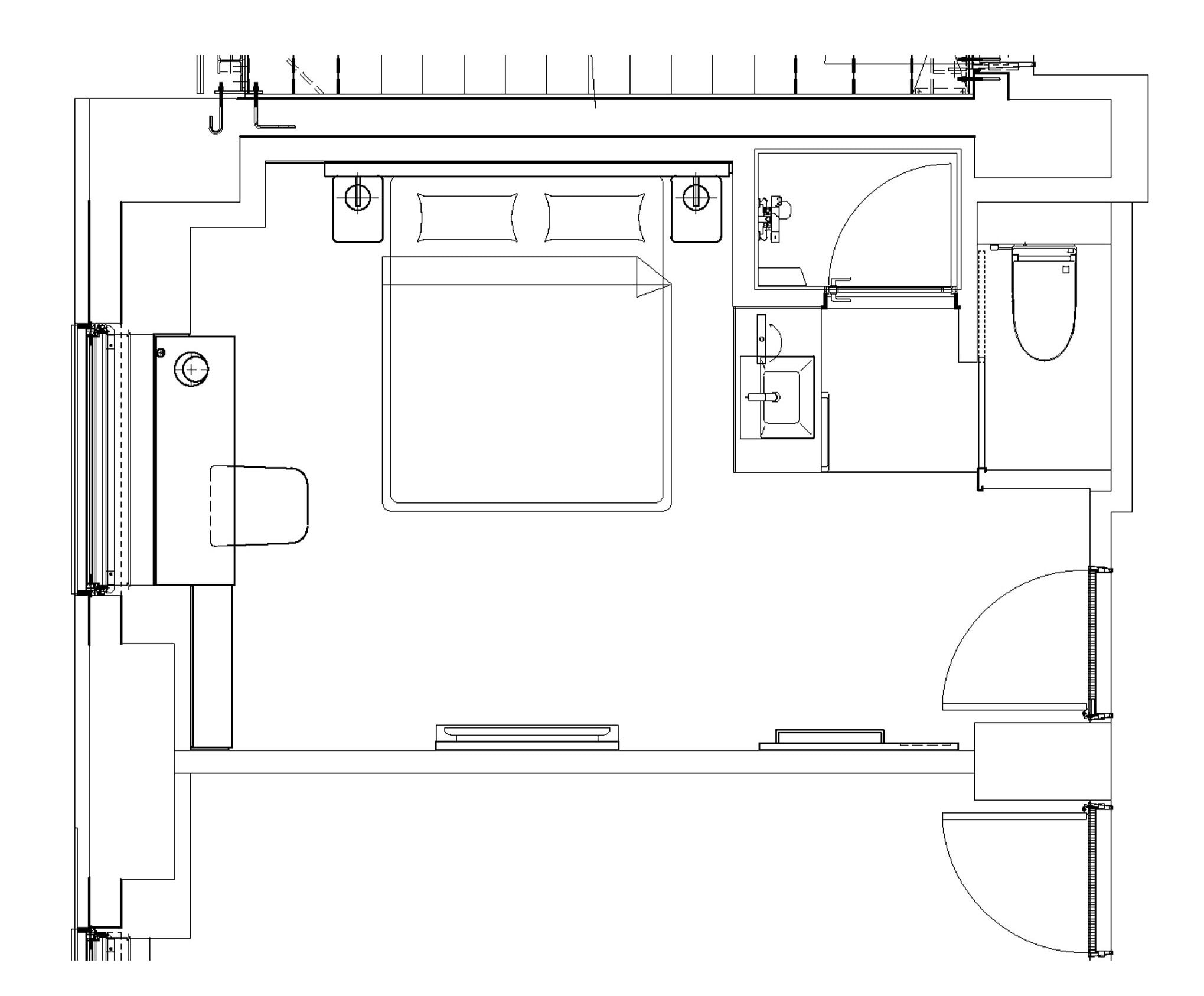 A floor plan of a hotel room with a bed, a desk, a chair, a wardrobe, and a bathroom.