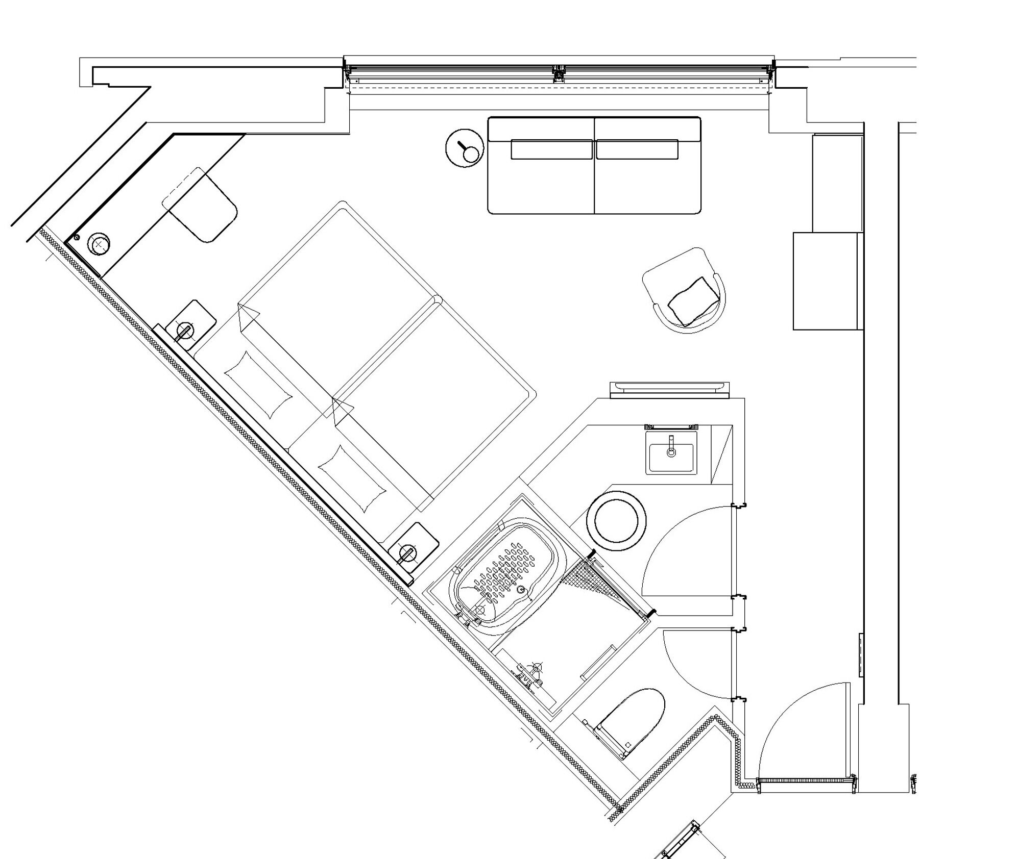 A floor plan of a hotel room with a bed, a desk, a chair, a small bathroom, and a seating area.