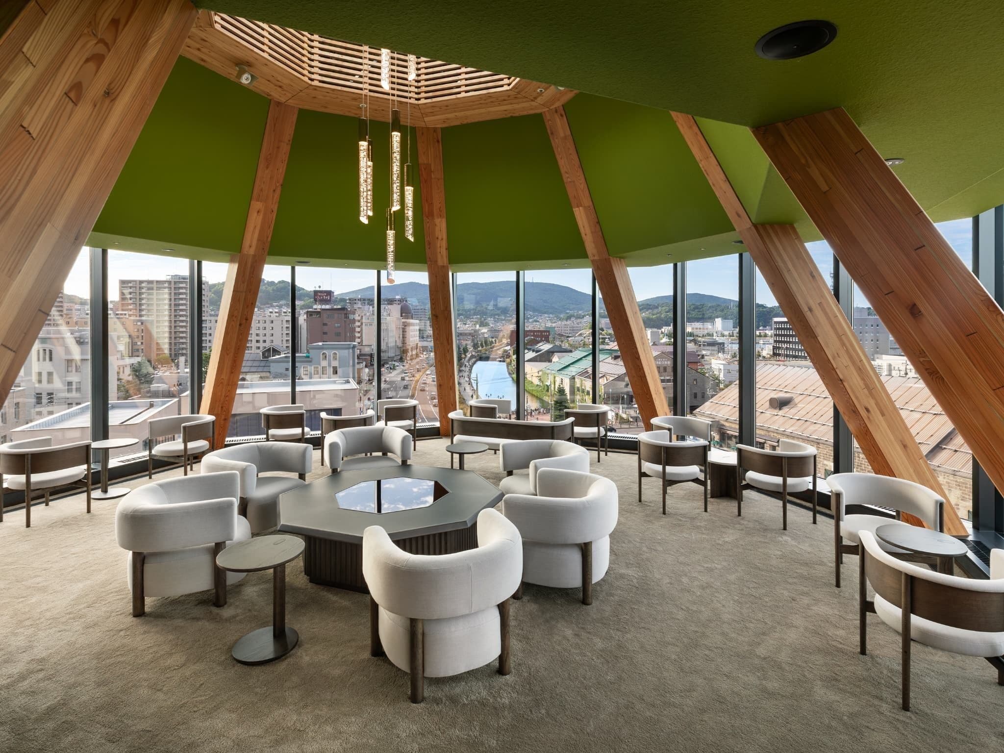 A modern conference room with a panoramic city view, featuring a unique wooden ceiling structure and comfortable seating.