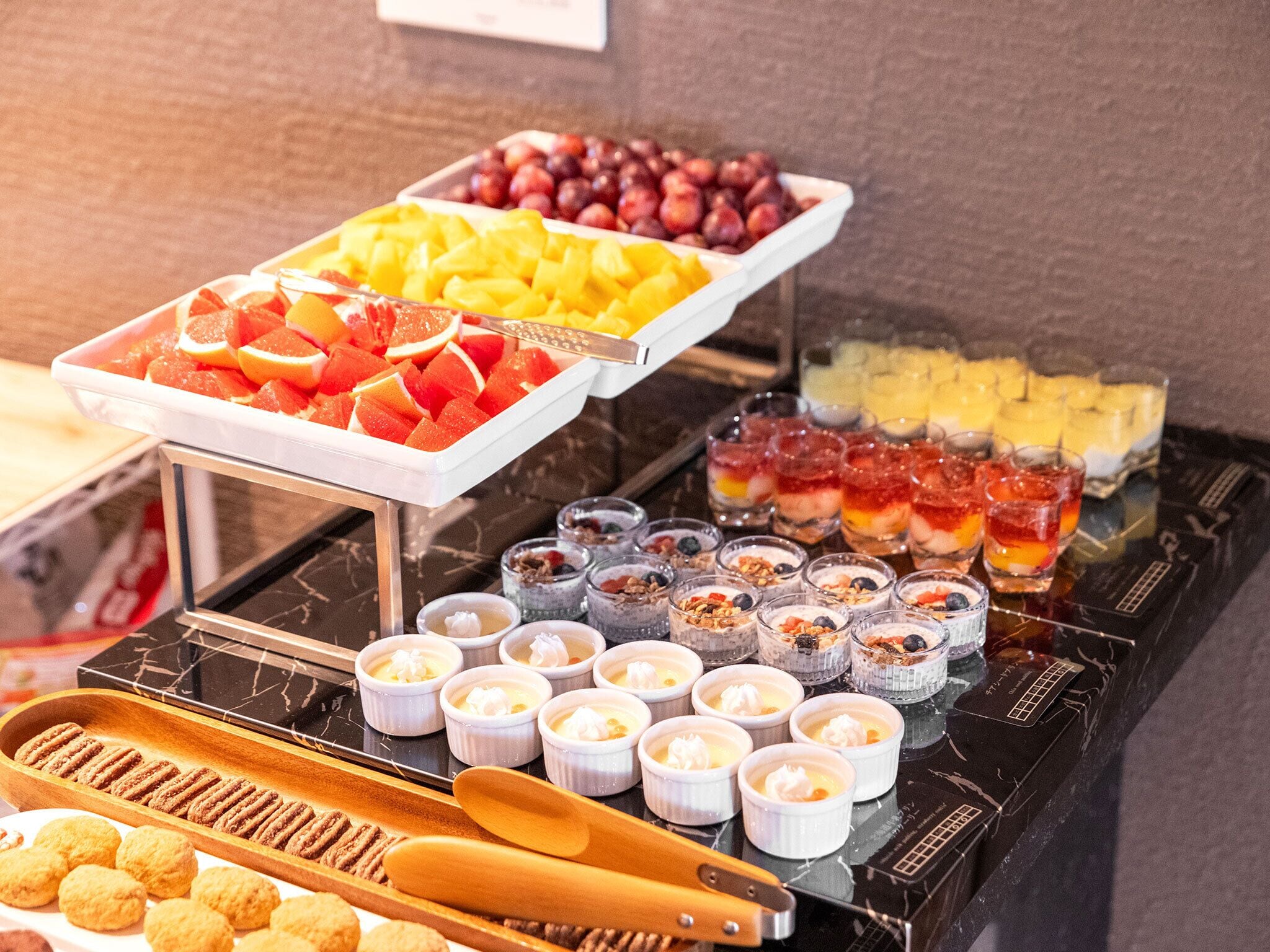 A buffet with various food items including fruits, desserts, and beverages.