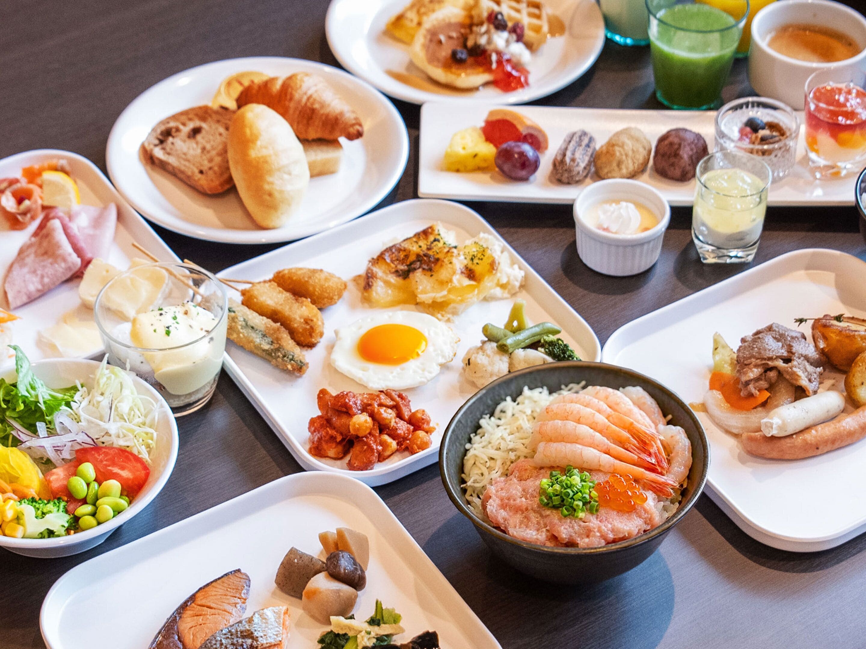 A variety of dishes on a table, including sushi, eggs, and various side dishes.